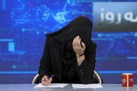 TV anchor Khatereh Ahmadi bows her head while wearing a face covering as she reads the news on TOLO NEWS, in Kabul, Afghanistan, Sunday, May 22, 2022. Afghanistan's Taliban rulers have begun enforcing an order requiring all female TV news anchors in the country to cover their faces while on-air. The move Sunday is part of a hard-line shift drawing condemnation from rights activists. (AP Photo/Ebrahim Noroozi)