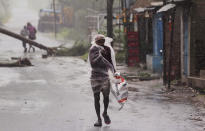 A man covers himself with a plastic sheet and walks in the rain ahead of Cyclone Amphan landfall, at Bhadrak district, in the eastern Indian state of Orissa, Wednesday, May 20, 2020. A strong cyclone blew heavy rains and strong winds into coastal India and Bangladesh on Wednesday after more than 2.6 million people were moved to shelters in a frantic evacuation made more challenging by coronavirus. (AP Photo)