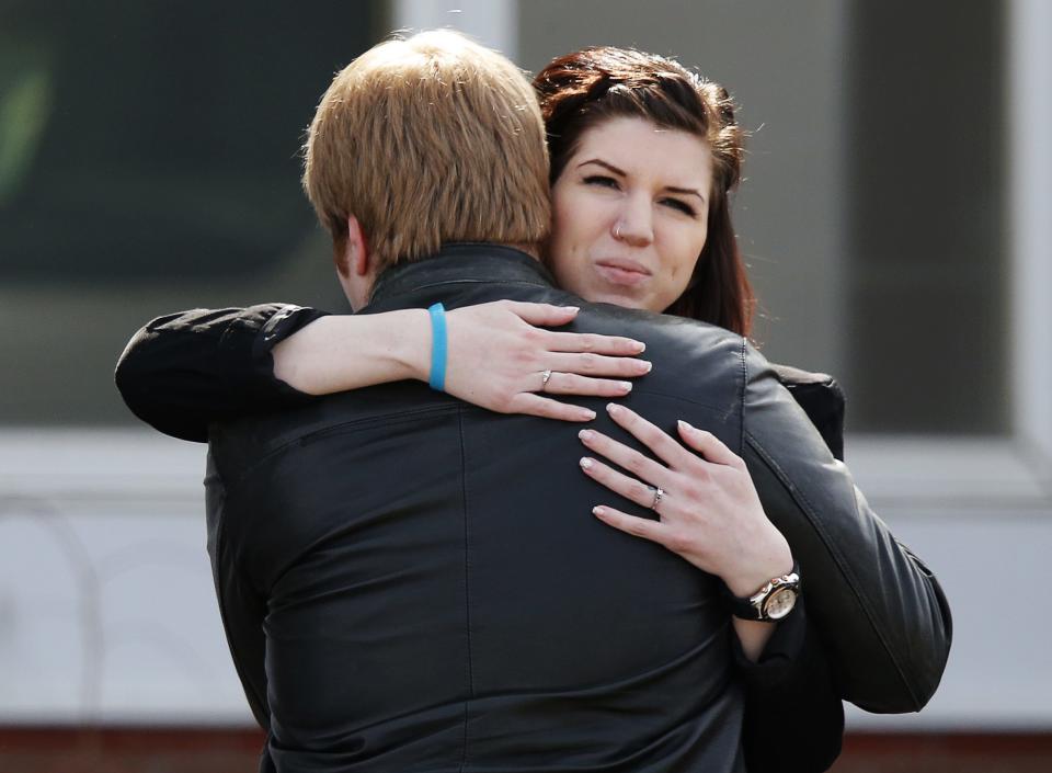 People hug after the funeral of Jordan Segura in Calgary, Alberta April 21, 2014. Matthew de Grood has been charged with killing Segura and four of his friends at a house party last week in Calgary's worst mass murder in the history of the city, according to local media reports. REUTERS/Todd Korol (CANADA - Tags: CRIME LAW OBITUARY)