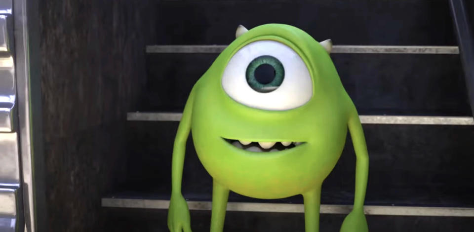Mike Wazowski from "Monsters University" is standing and smiling