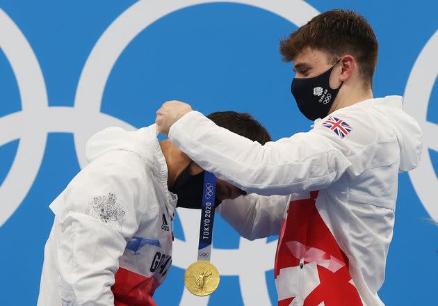 Great Britain's Tom Daley receives a gold medal from teammate Matty Lee during the medal presentation for the men's synchronized 10 meter platform event on July 26. (Photo: Clive Rose via Getty Images)