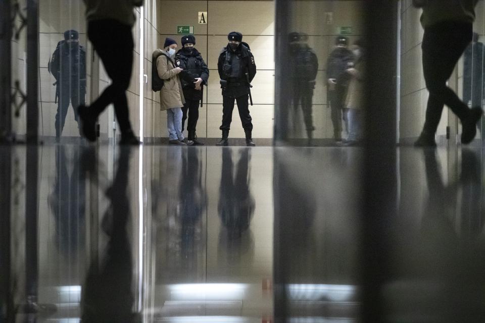 Police stand guard at the Foundation for Fighting Corruption office in Moscow, Russia, Wednesday, Jan. 27, 2021. Police are searching the Moscow apartment of jailed Russian opposition leader Alexei Navalny, another apartment where his wife is living and two offices of his anti-corruption organization. Navalny's aides reported the Wednesday raids on social media. (AP Photo/Pavel Golovkin)