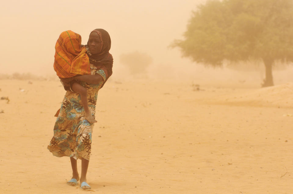 A girl carries her baby sibling through a haze of dust in Sidi Village, in Kanem Region. She is taking him to be screened for malnutrition at a mobile outpatient centre for children, operated by one nurse and four nutrition workers. The programme is new to the area. Several months ago, most children suffering from severe malnutrition had to be transported to health centres in the town of Mundo, 12 kilometres away, or in the city of Mao, some 35 kilometres away. In April 2010 in Chad, droughts have devastated local agriculture, causing chronic food shortages and leaving 2&nbsp;million people in urgent need of food aid. Due to poor rainfall and low agricultural yields, malnutrition rates have hovered above emergency thresholds for a decade. But the 2009 harvest was especially poor, with the production of staple crops declining by 20 percent to 30 percent. Food stocks have since dwindled, and around 30 percent of cattle in the region have died from lack of vegetation.&nbsp;