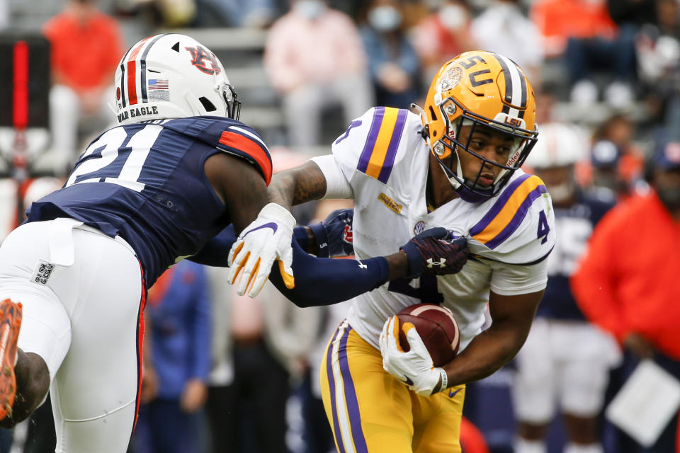 LSU running back John Emery Jr. (4) breaks free from Auburn defensive back Smoke Monday (21) as he carries the ball during the first quarter of an NCAA college football game on Saturday, Oct. 31, 2020, in Auburn, Ala. (AP Photo/Butch Dill)