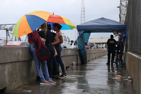 A group of women from Cuba and Guatemala seeking asylum wait at the middle of the Brownsville-Matamoros International Bridge in hopes of entering the U.S. near Brownsville, Texas, U.S., June 20, 2018. REUTERS/Loren Elliott