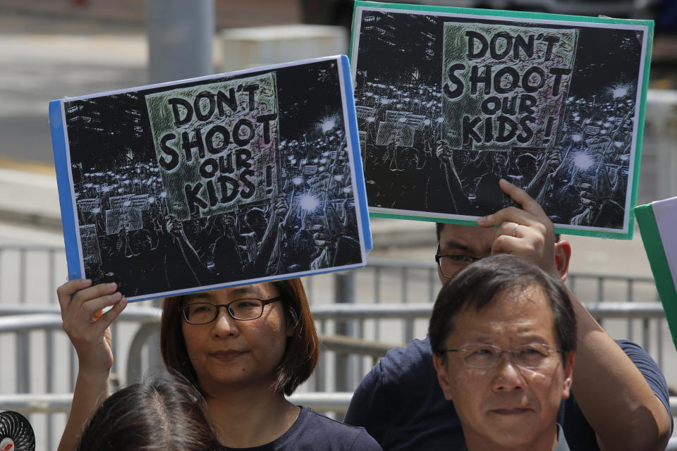 Various of activist groups from parents and religious hold placards outside the government office demanding to stop shooting their kids in Hong Kong, Thursday, June 20, 2019. A Hong Kong student group demanded Wednesday that the city completely scrap a politically charged extradition bill and agree to investigate police tactics against protesters before a Thursday deadline or face further street demonstrations. (AP Photo/Kin Cheung)