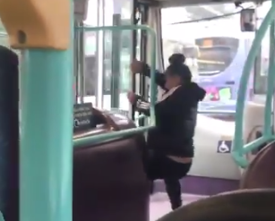 A woman in Manchester pries open a door on a moving bus in order to chase her fleeing boyfriend. (Photo: Sian Bayliss via Twitter)