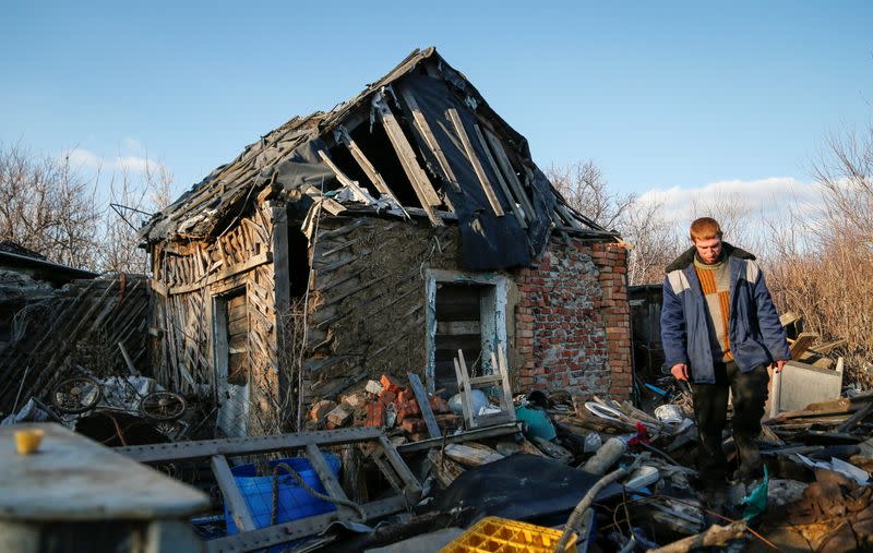 Local resident Victor Luksha walks past his family's property damaged by shelling in Horlivka