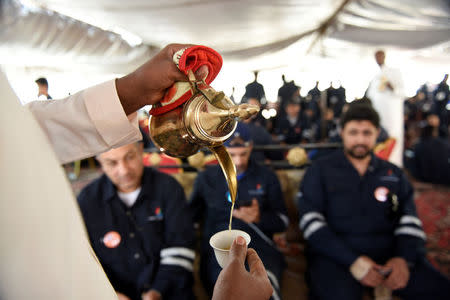 Traditional Arabic coffee is offered as Kuwait Oil and Petrochemical Industries Union workers sit in a shaded area on the first day of an official strike over public sector pay reforms, in Ahmadi, Kuwait April 17, 2016. REUTERS/Stephanie McGehee/File Photo