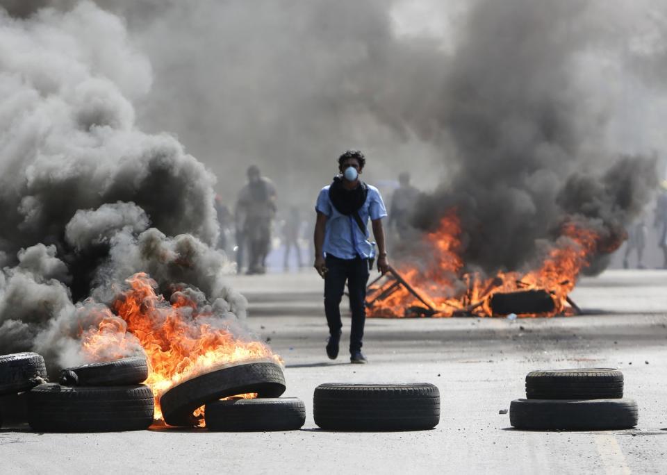 A protester walks between burning barricades in Managua, Nicaragua, in 2018.