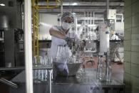 A worker organizes bottles to be filled with antiseptic alcohol at the Santa Teresa rum factory in La Victoria, Aragua state, Venezuela, Wednesday, April 1, 2020. Venezuela's premier rum distillery and one of Venezuela's few private businesses says that most of its production will be for antiseptic alcohol, in an effort to help contain the spread of the new coronavirus. (AP Photo/Ariana Cubillos)