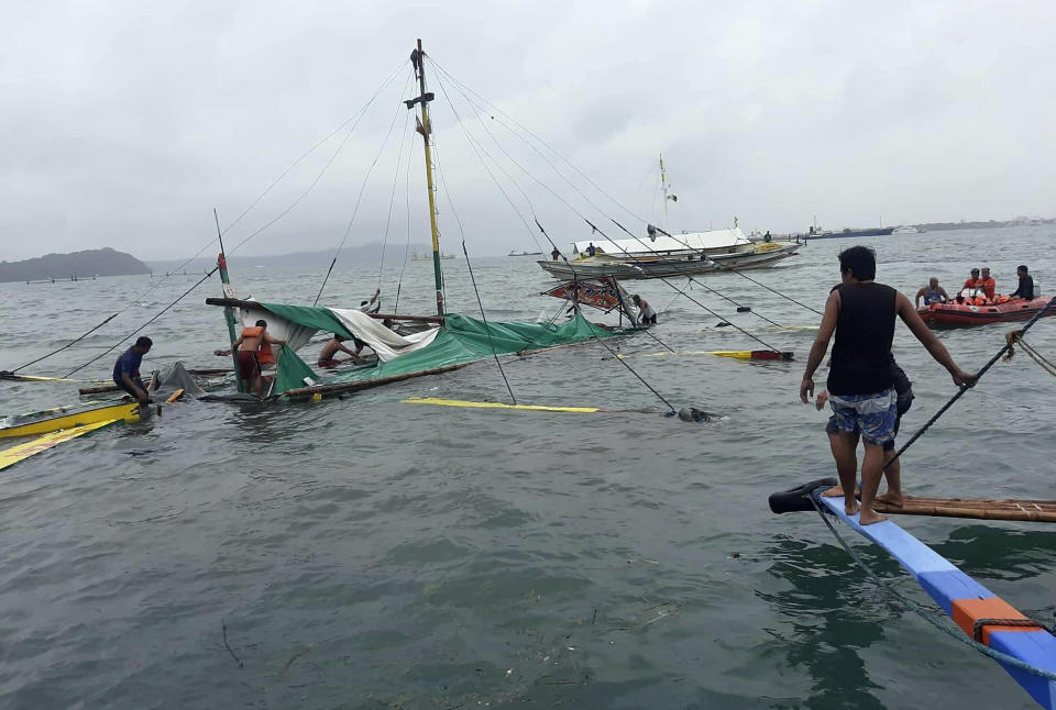 In this photo provided by the Philippine Red Cross, rescuers checks the remains of a ferry boat after it capsized due to bad weather in the waters between Guimaras and Iloilo provinces, central Philippines on Saturday Aug. 3, 2019. Several people died and 31 others were rescued when three ferry boats separately capsized in bad weather Saturday between two central Philippine island provinces, the coast guard said. (Philippine Red Cross via AP)