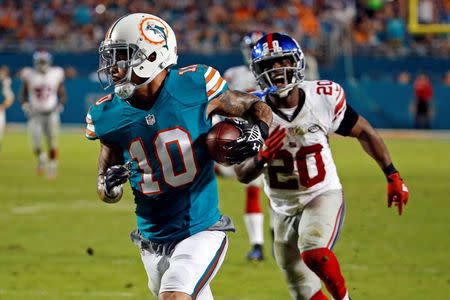 Dec 14, 2015; Miami Gardens, FL, USA; Miami Dolphins wide receiver Kenny Stills (10) hauls in a touchdown catch in front of New York Giants cornerback Prince Amukamara (20) during the second half at Sun Life Stadium. Mandatory Credit: Steve Mitchell-USA TODAY Sports