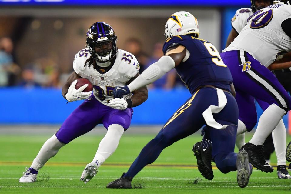 Nov 26, 2023; Inglewood, California, USA; Baltimore Ravens running back Gus Edwards (35) moves the ball against Los Angeles Chargers linebacker Kenneth Murray Jr. (9) during the second half at SoFi Stadium. Mandatory Credit: Gary A. Vasquez-USA TODAY Sports