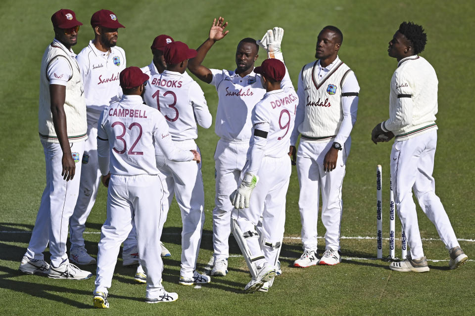 The West Indies Kemar Roach, centre, celebrates with his teammates after taking the wicket of New Zealand's Tom Latham during play on day one of the first cricket test against New Zealand in Hamilton, New Zealand, Thursday, Dec. 3, 2020. (Andrew Cornaga/Photosport via AP)