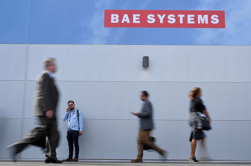 FILE PHOTO: Trade visitors walk past an advertisement for BAE Systems at Farnborough International Airshow in Farnborough, Britain