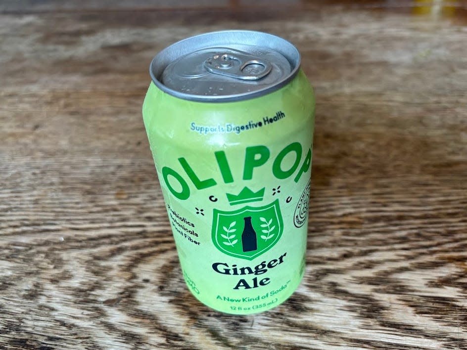 A can of ginger-ale Olipop on a wooden table.