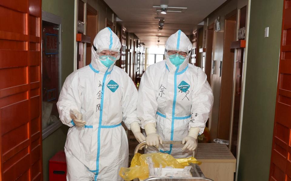 Medical staff attend a quarantine hotel in China's eastern Jiangsu province, amid a recent outbreak - AFP