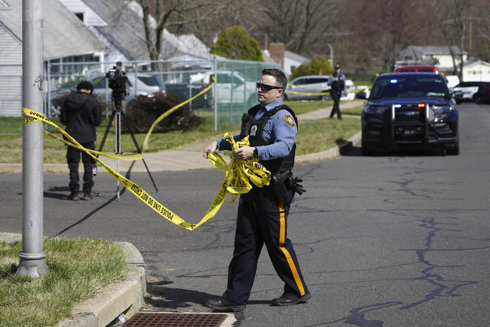 A police officer removes crime scene tape after a shooting was reported in Levittown, Pa., Saturday, March 16, 2024. Authorities have issued a shelter-in-place order following the shooting of multiple people in a suburban Philadelphia township. (AP Photo/Matt Rourke)