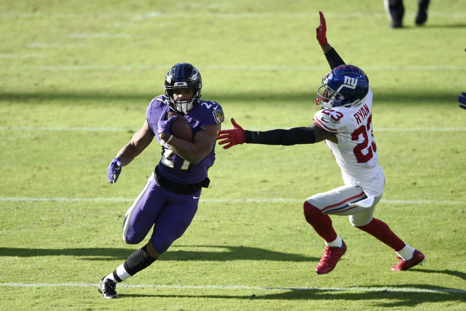 Baltimore Ravens running back J.K. Dobbins (27) runs with the ball as New York Giants free safety Logan Ryan (23) tries to stop him during the first half of an NFL football game, Sunday, Dec. 27, 2020, in Baltimore. (AP Photo/Gail Burton)
