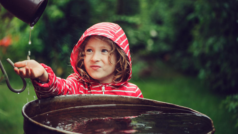 Young girl catching water from gutter