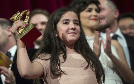 Hana Saeidi, the niece of Iranian film director Jafar Panahi appears on stage with jury members and prize winners after accepting the Golden Bear for Best Film on her uncle's behalf, during the awards ceremony at the 65th Berlinale International Film Festival in Berlin February 14, 2015. REUTERS/Hannibal Hanschke