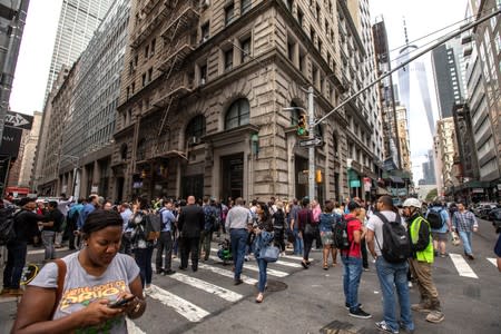 Commuters are seen on Fulton Street after the Fulton Street subway station was closed as police investigated two suspicious packages in Manhattan