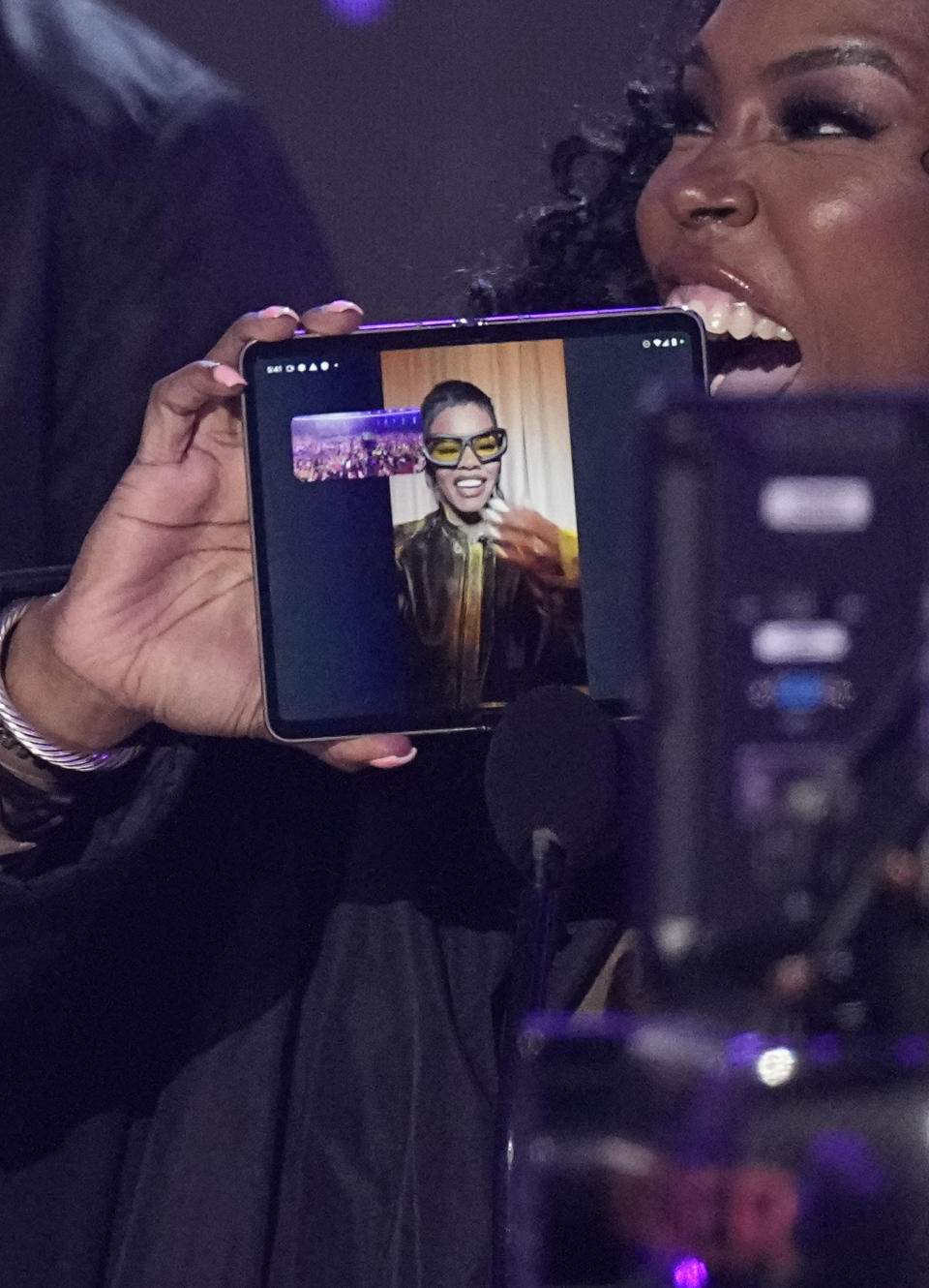 Nikki Taylor, mother of Teyana "Spike Tey" Taylor, holds a phone up as her daughter accepts the award for video director of the year remotely at the BET Awards on Sunday, June 25, 2023, at the Microsoft Theater in Los Angeles. (AP Photo/Mark Terrill)