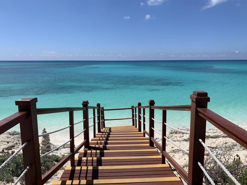 A view of stairs leading down to a white-sand beach and turquoise ocean on Cuba's Sunshine Coast in Cayo Largo 