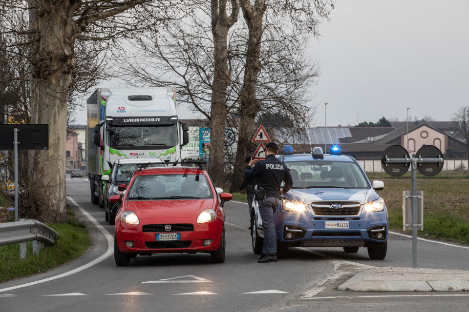 CASALPUSTERLENGO, ITALY - FEBRUARY 23: An Italian National Police officer talks to a driver in a car on February 23, 2020 in Casalpusterlengo, south-west Milan, Italy. Casalpusterlengo is one of the ten small towns placed under lockdown earlier this morning as a second death from coronavirus sparked fears throughout the Lombardy region. (Photo by Emanuele Cremaschi/Getty Images)