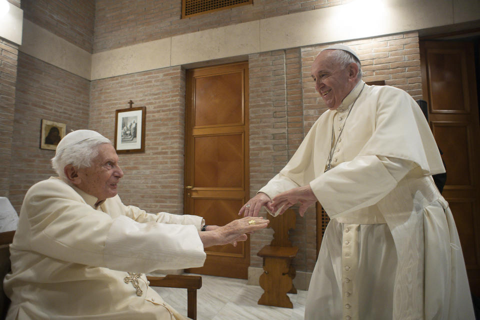 FILE - In this Nov. 28, 2020 file photo Pope Francis hold hands with Pope Emeritus Benedict XVI as he pays him a visit at the Vatican. Emeritus Pope Benedict XVI has said he hopes to soon join a beloved professor friend in “the afterlife,” in a sign that the 94-year-old retired pontiff is not only preparing for his death but welcoming it. Benedict penned an Oct. 2 letter to a German priest, thanking him for letting him know of the passing of the Rev. Gerhard Winkler, a Cistercian priest and colleague of Benedict.(Vatican Media via AP)