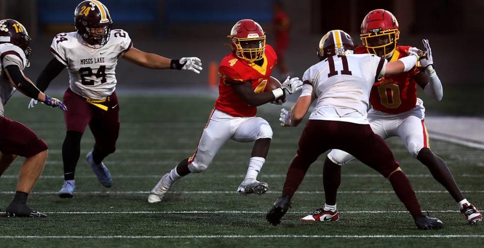 Kamiakin running back Makram Altahir (4) cuts away from defenders behind the block by his teammate David Kuku during their game against the Moses Lake Mavericks at Lampson Stadium in Kennewick. Bob Brawdy/bbrawdy@tricityherald.com