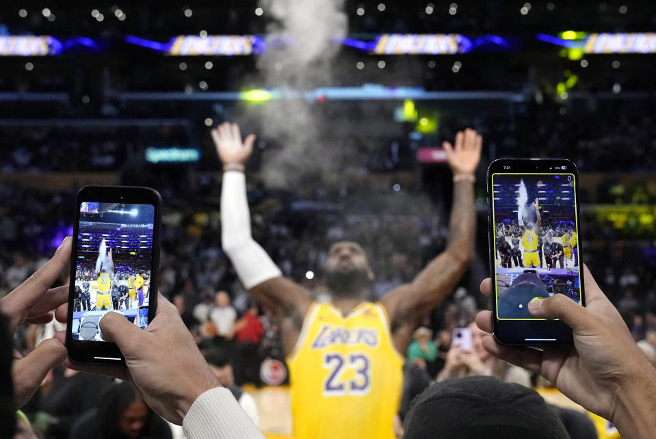 FILE - Los Angeles Lakers forward LeBron James tosses powder in the air as fans take video prior to an NBA basketball game against the Los Angeles Clippers Wednesday, Nov. 1, 2023, in Los Angeles. The photo was part of a series of images by photographer Mark J. Terrill which won the Thomas V. diLustro best portfolio award for 2023 given out by the Associated Press Sports Editors during their annual winter meeting. (AP Photo/Mark J. Terrill, File)