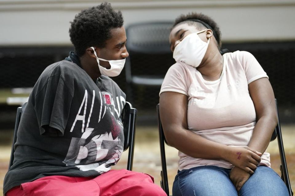 Markel Edwards and Keshontea Kenneday speak with each other in a shelter ahead of Hurricane Delta, Friday, Oct. 9, 2020, in Lake Charles, La. (AP Photo/Gerald Herbert)