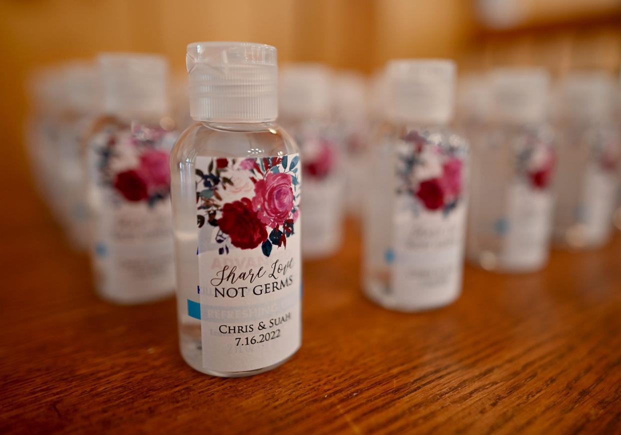 "Share Love, Not Germs," declared bottles of hand sanitizer at a ceremony for Chris and Suah Yi of Ashland, Massachusetts. Because of COVID-19, the couple's traditional Korean wedding was delayed until three years after their marriage began.