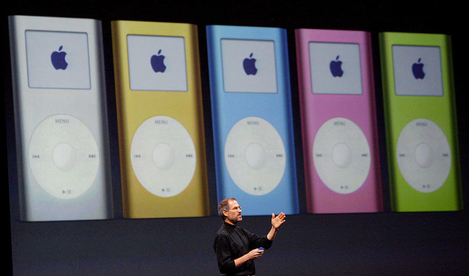 Steve Jobs onstage with a colorful array of iPod Minis behind him