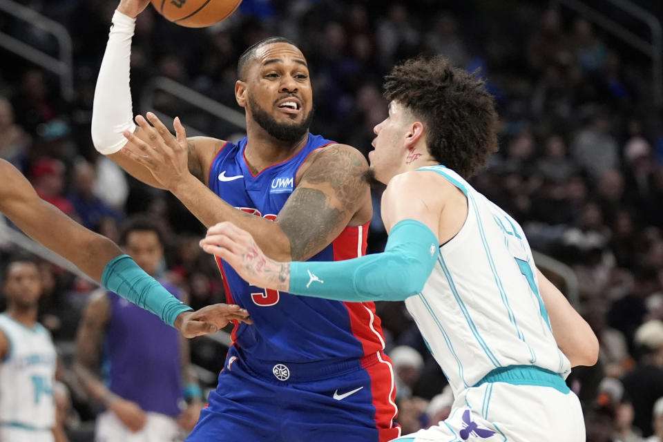 Detroit Pistons guard Monte Morris passes as Charlotte Hornets guard LaMelo Ball (1) defends during the second half of an NBA basketball game, Wednesday, Jan. 24, 2024, in Detroit. (AP Photo/Carlos Osorio)