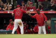 Los Angeles Angels' Mike Trout (27) celebrates with manager Ron Washington after scoring on a wild pitch by Philadelphia Phillies relief pitcher Seranthony Dominguez and throwing error by catcher Garrett Stubbs during the seventh inning of a baseball game, Monday, April 29, 2024, in Anaheim, Calif. Ehire Adrianza also scored. (AP Photo/Ryan Sun)