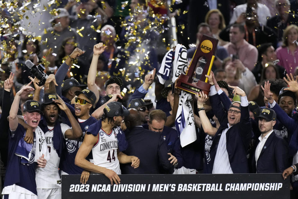 FILE - Connecticut players and coaches celebrate their win over San Diego State in the men's national championship college basketball game in the NCAA Tournament on Monday, April 3, 2023, in Houston. Connecticut won 76-59. Defending champion UConn comes into this season having lost the three biggest stars from last year's NCAA title team to the NBA. (AP Photo/Godofredo A. Vasquez, File)