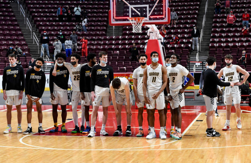 A multi-racial modern team stands on the court together