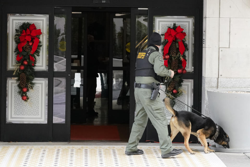 A K-9 team works in the area of an explosion in downtown Nashville, Tenn., Friday, Dec. 25, 2020. Buildings shook in the immediate area and beyond after a loud boom was heard early Christmas morning.(AP Photo/Mark Humphrey)