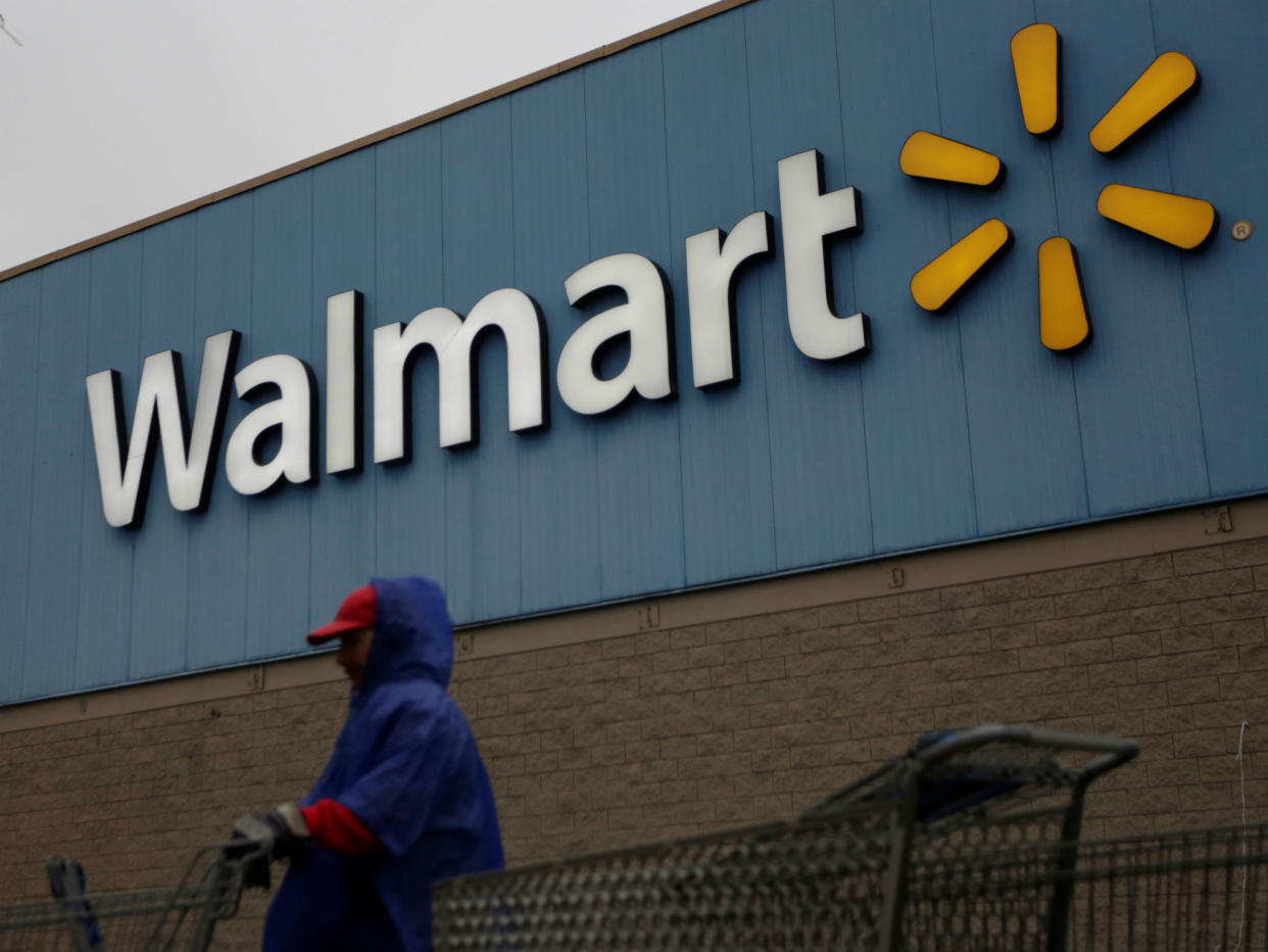 An employee arranges shopping carts in front of a Walmart store: REUTERS/Daniel Becerril