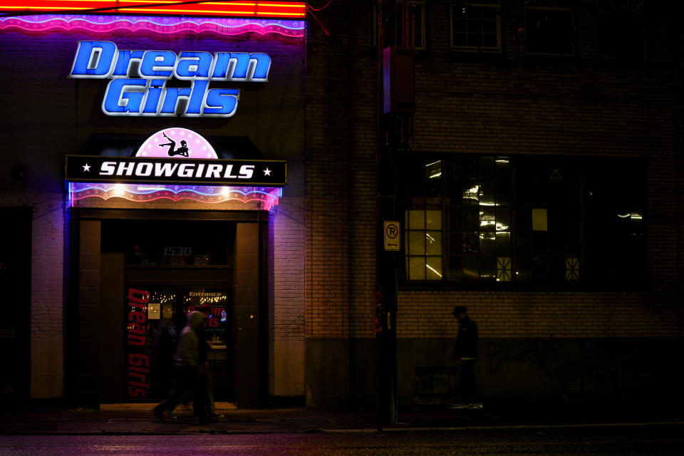 People walk by the Dream Girls at SoDo strip club, Monday, Feb. 5, 2024, in Seattle. Adult dancers are fighting for bills to pass in the state Legislature that would expand statewide protections to workers, like having a security guard at each club, keypad codes to enter dressing rooms and deescalation training. (AP Photo/Lindsey Wasson)