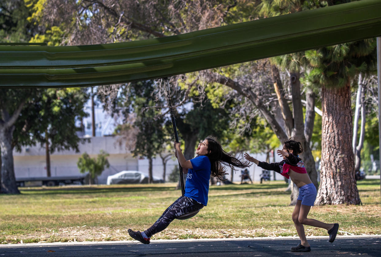 Kids play on a swing in the shade amidst a sunny, hot summer day at the Sun Valley Recreation Center in Sun Valley Tuesday, June 27, 2023.&nbsp; / Credit: Allen J. Schaben