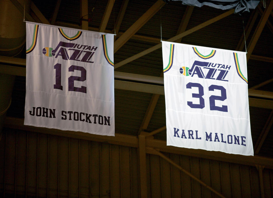 Former Utah Jazz forward Karl Malone's #32 jersey is retired to the rafters of the Delta Center next to long-time team mate John Stockton's #12 jersey during halftime of a Utah Jazz and Washington Wizards NBA basketball game in Salt Lake City March 23, 2006.  REUTERS/Steve Wilson