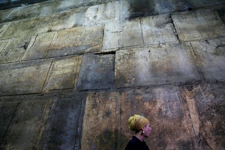 Israel Antiquities Authority archaeologist Tehillah Lieberman stands next to a part of the Western Wall, during a media tour revealing a theatre-like structure which was discovered during excavation works underneath Wilson's Arch, in the Western Wall tunnels in Jerusalem's Old City October 16, 2017. REUTERS/Ronen Zvulun