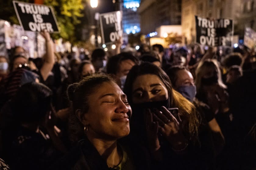 WASHINGTON, DC - NOVEMBER 07: Angelique McKenna, 25, of Arlington, center, gets emotional listening to President-elect Joe Biden's speech, played over a loudspeaker at Black Lives Matter Plaza near The White House on Saturday, Nov. 7, 2020 in Washington, DC. (Kent Nishimura / Los Angeles Times)