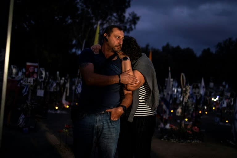 Dos personas se abrazan durante la ceremonia de homenaje en el lugar del festival Nova, atacado por militantes palestinos de Hamás, cerca del kibutz de Reim, en el sur de Israel, el 7 de octubre de 2024, al cumplirse el primer aniversario (John Wessels)