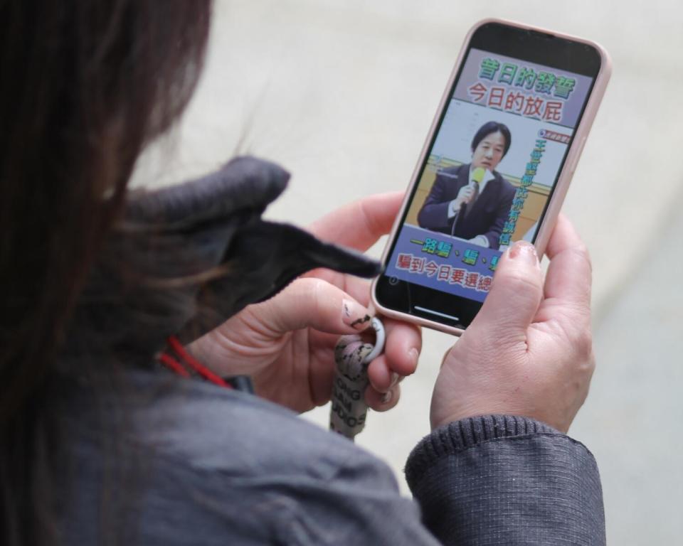 A woman looks at a social media post on her phone.