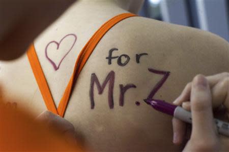 Eastside Catholic Middle School student Sarah Merlino gets a message of support written on her back for former Vice Principal and swimming coach Mark Zmuda during a swim meet at Rainier Beach Pool in Seattle, Washington, December 20, 2013. REUTERS/David Ryder